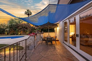 A patio with a pool, outdoor furniture, and a blue shade sail. - Dandelion by Avantstay Pool 0 2mi to Downtown (Palm Springs)