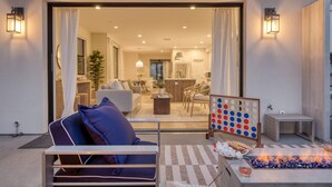 Een open woonkamer met een bank, een salontafel en een open haard.
