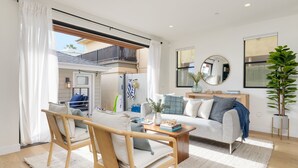 Een moderne woonkamer met een bank, salontafel en stoelen. Er is een balkon met een leuning en uitzicht op buiten.
