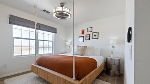 A modern bedroom with a four-poster bed, large windows, and a view of the outdoors. - Casa De Kota by Avantstay Pool Firepit Games Secluded Chic (Joshua Tree)