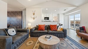 A modern living room with a grey sofa set, a wooden coffee table, and a patterned rug. - Casa De Kota by Avantstay Pool Firepit Games Secluded Chic (Joshua Tree)