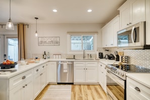 A modern kitchen with white cabinets, stainless steel appliances, and a large window. - Old Town Treasure by Avantstay Central Location (Scottsdale)