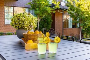 A table with drinks, a basket of lemons, and a potted plant. - The Magnolia 10 - Avantstay Germantown w Private Balcony (Nashville)
