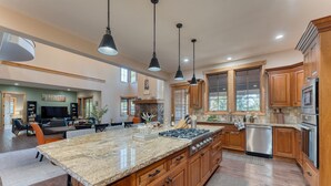A spacious kitchen with granite countertops, wooden cabinets, and stainless steel appliances. - Grays Crossing by Avantstay Stunning 4bdr Cabin (Truckee)