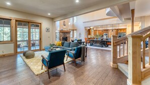 A spacious living area with a fireplace, a dining area, and a kitchen. - Grays Crossing by Avantstay Stunning 4bdr Cabin (Truckee)