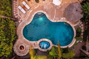 An aerial view of a swimming pool with a hot tub, lounge chairs, and a fire pit area surrounded by greenery. - Wavebreak by Avantstay Close to Beaches Surfing (Solana Beach)