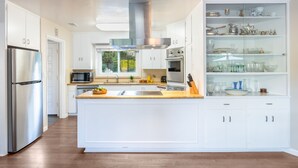 A modern kitchen with white cabinetry, stainless steel appliances, and a central island. - East Valley Manor by Avantstay Minutes to the Beach (Santa Barbara)
