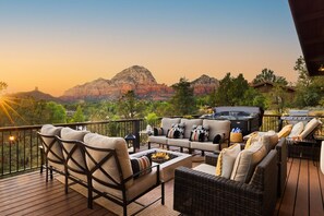 A deck with outdoor furniture, a fire pit, and a grill area, overlooking a mountainous landscape. - Roca Roja by Avantstay Mountain Views in the Heart of Sedona (Sedona)