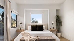 A modern bedroom with a large bed, bedside tables, a bench, and a window. - Roca Roja by Avantstay Mountain Views in the Heart of Sedona (Sedona)