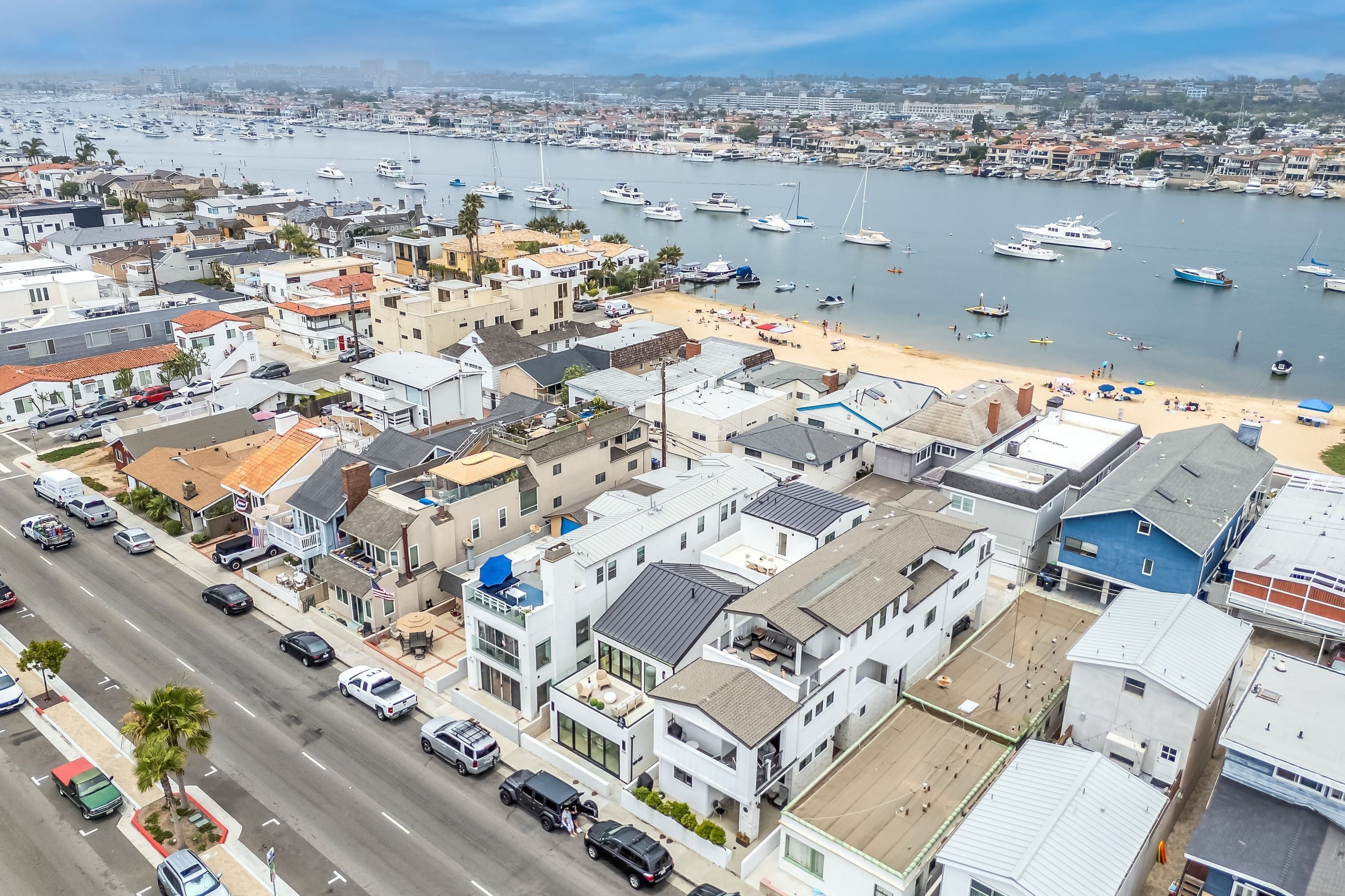 Un pueblo costero con un puerto deportivo, edificios residenciales y una playa.