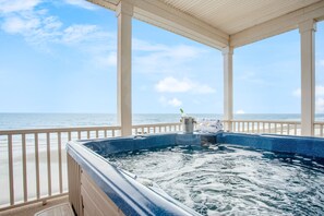 A hot tub with a view of the ocean, a beach, and a covered area with a railing. - Poseidon By Avantstay On The Beach Two Ocean Facing Balconies Hot Tub (Folly Beach)