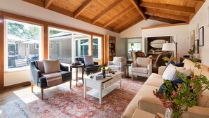 A spacious living room with a high wooden ceiling, large windows, and a mix of modern and classic furniture. - Wildflower by Avantstay Gorgeous Wine Country Home w Pool Bocce Ball Court Huge Yard (Sonoma)