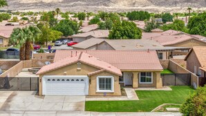 A residential area with houses, a well-maintained lawn, and a mountain backdrop. - Pacifica Sur by Avantstay Pool Hot Tub Gazebo (Indio)