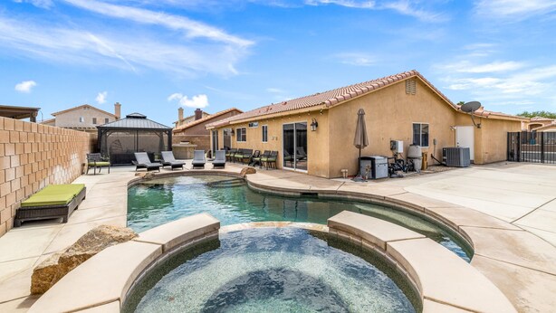 A residential pool area with a hot tub, lounge chairs, and a covered patio. - Pacifica Sur by Avantstay Pool Hot Tub Gazebo (Indio)