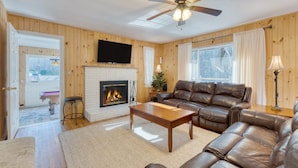 A cozy living room with a fireplace, leather sofa, and a ceiling fan. - Creekside Haven Gatlinburg Escape by a Bubbling Creek Near Top Attractions (Gatlinburg)