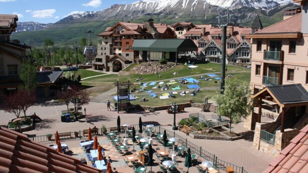 A resort with multiple buildings, outdoor seating areas, and a mountain backdrop. - Blue Mesa Penthouse by Avantstay Buyout of 3 Units Ski-in Ski-out Condo (Telluride)