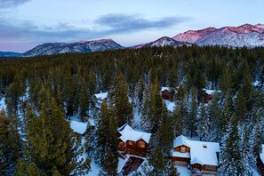 A cabin surrounded by snow-covered trees and mountains. - Cherry Hills Spacious Tahoe Cabin With Deck Fireplace Open Interiors (South Lake Tahoe)
