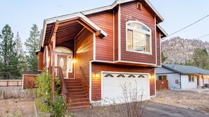 A two-story house with a front porch, a garage, and a hillside backdrop. - Blitzen by Avantstay Pet-friendly Tahoe Retreat (South Lake Tahoe)