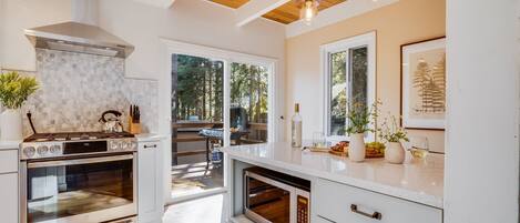 A modern kitchen with a built-in oven, microwave, and a large window offering a view of the outdoors.