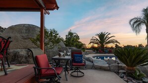An outdoor seating area with a pool, red chairs, and a large rock formation. - Chardonnay Charm by Avantstay Luxe Group Retreat w Pool Mins to Wineries (Temecula)