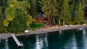 Ein Seehaus mit Steg, umgeben von dichtem Wald.