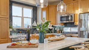 Une cuisine moderne avec des armoires en bois, des appareils en acier inoxydable et un îlot en marbre.