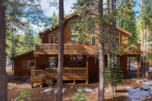 A two-story log cabin with a balcony and a deck, surrounded by trees and snow. - Hansel by Avantstay Pool Table 5mins to Skiing (Truckee)