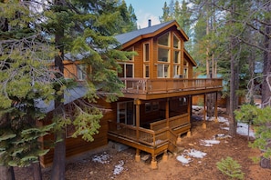 A log cabin with a wooden deck and large windows, surrounded by trees. - Hansel by Avantstay Pool Table 5mins to Skiing (Truckee)