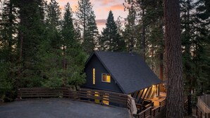 A cabin with a dark roof, wooden deck, and a small porch area. - Washoe Way by Avantstay Luxury Tahoe Retreat A Location w Beach Access (Tahoe City)