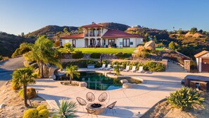A large house with a pool, surrounded by a landscaped garden and a mountain backdrop. - Colina by Avantstay Secluded Mountain Top Oasis w Pool Hot Tub Putting Green (Murrieta)