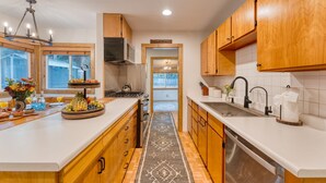 Une cuisine moderne avec des meubles en bois, un îlot central et une vue sur le jardin.
