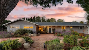 A house with a stone pathway leading to the entrance, surrounded by various plants and trees. - Hummingbird Haven by Avantstay Dog-friendly Near the Beach Huge Yard Hot Tub (Santa Barbara)