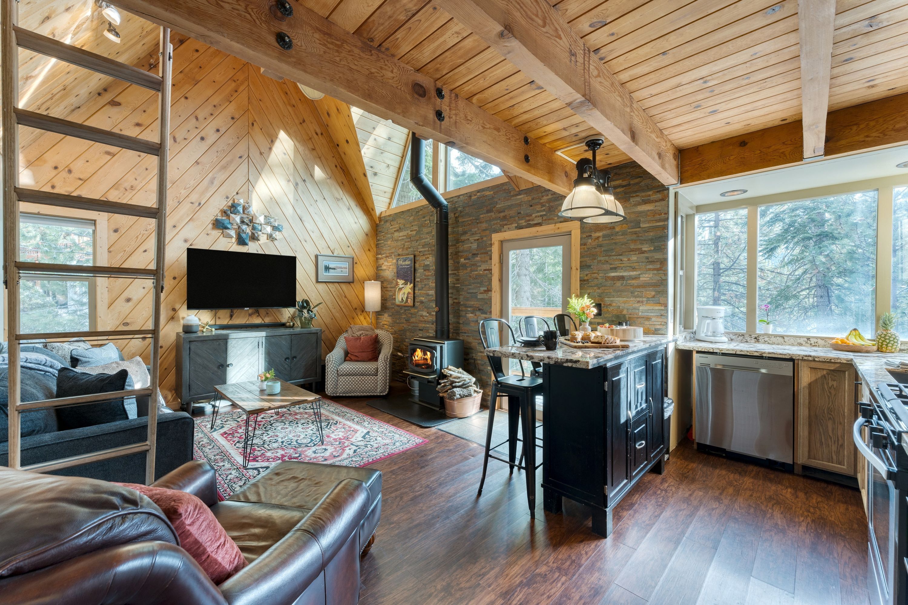 A cozy cabin interior with a living area, kitchen, and dining space.