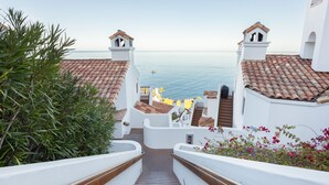 A staircase leading to a terrace with a sea view, white walls, and terracotta roof tiles. - Camino De Flores by Avantstay Views Pool Beach Access Community Amenities (Avalon)