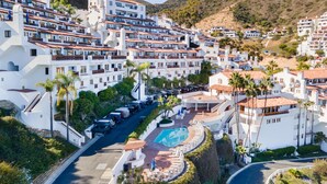 A coastal residential area with white buildings, a curved road, and a swimming pool. - Camino De Flores by Avantstay Views Pool Beach Access Community Amenities (Avalon)