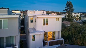 A modern two-story house with large windows, a balcony, and a view of the surrounding neighborhood. - Casa do Sol by Avantstay Rooftop Deck w Ocean Views 2 Blocks to Beach (Pismo Beach)