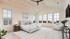 A spacious bedroom with a large bed, multiple windows, a ceiling fan, and a view of the outside. - Katydid Beach Bungalow by Avantstay Gulf Views New Construction in Seagrove (Santa Rosa Beach)