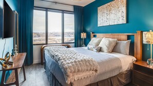 Une chambre à coucher moderne avec un grand lit, un bureau et une télévision.