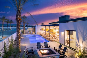 A rooftop pool area with lounge chairs, a fire pit, and umbrellas. - The Reserve at Polo Villas 12 by Avantstay (La Quinta)