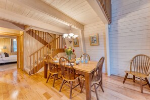 A dining area with wooden furniture, a chandelier, and a staircase leading to another room. - Lundy Bearden Serene Tahoe Retreat With Deck Fireplace and Forest Views (Carnelian Bay)