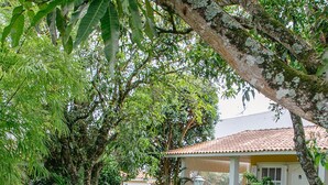 A garden pathway leading to a building with a tiled roof and outdoor seating. - Alambari Village (Alambari)