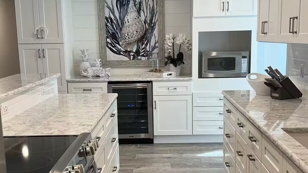 A modern kitchen with white cabinetry, a stainless steel stove, a microwave, and a built-in oven.