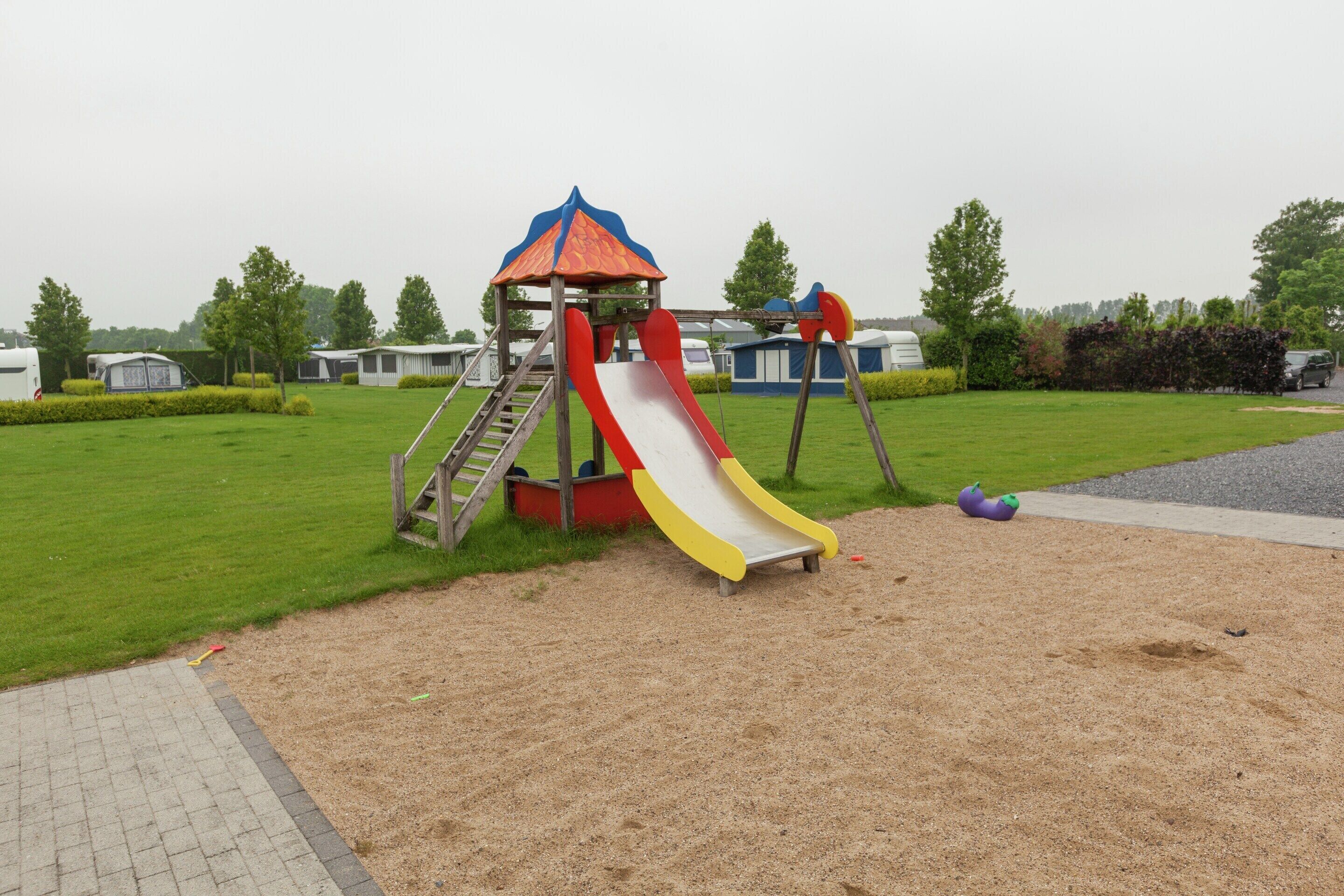 A playground with a slide and climbing structure.