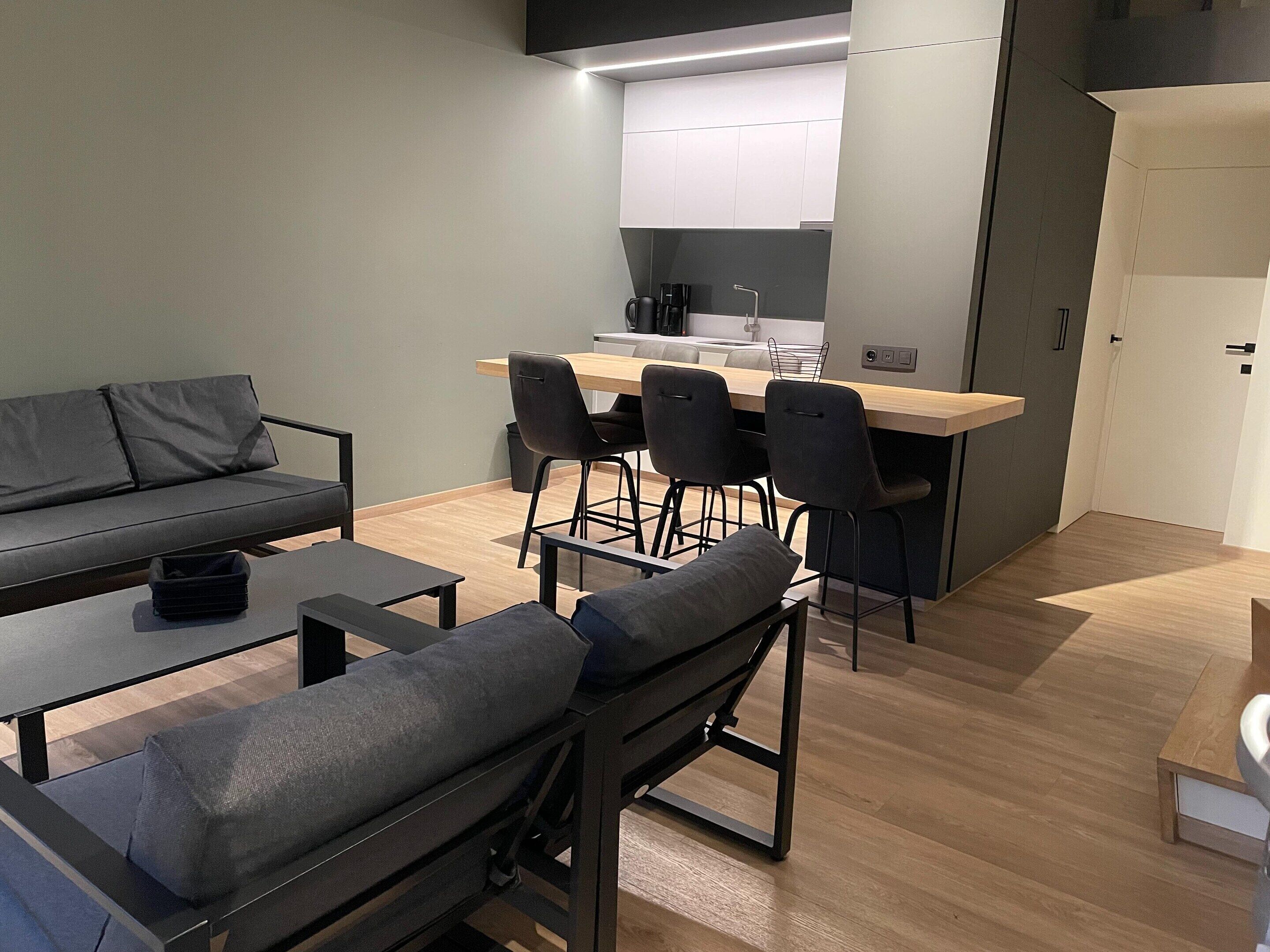 Une cuisine moderne dotée d’un îlot central, de tabourets de bar et d’une table à manger avec des chaises.