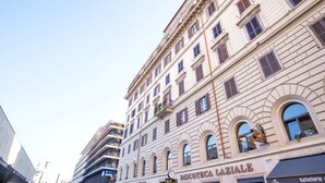 A multi-story building with a classical architectural style, featuring arched windows and a prominent entrance. - Elegantis Giolitti Suite Apartment with Private Balcony (Roma)