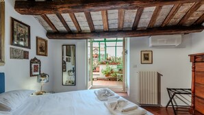 A bedroom with a bed, a mirror, a radiator, and a view of the outside. - Elegantis Dimora dell'Architetto in Campo de' Fiori With private terrace (Roma)