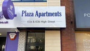 Schild für Plaza Apartments in der High Street 63a und 63b.