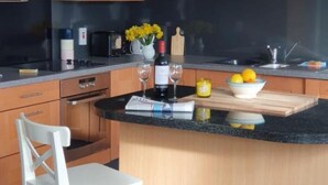 Eine Küche mit Kochinsel, Holzschränken, einer Mikrowelle, einem Toaster und einem Spülbecken.