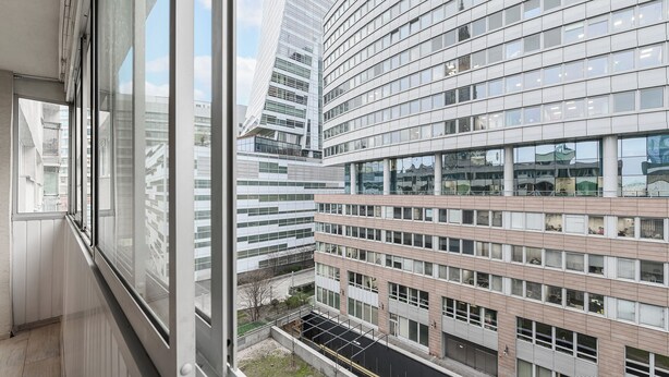 Un edificio moderno con fachada curva, amplias ventanas y un patio interior visible.