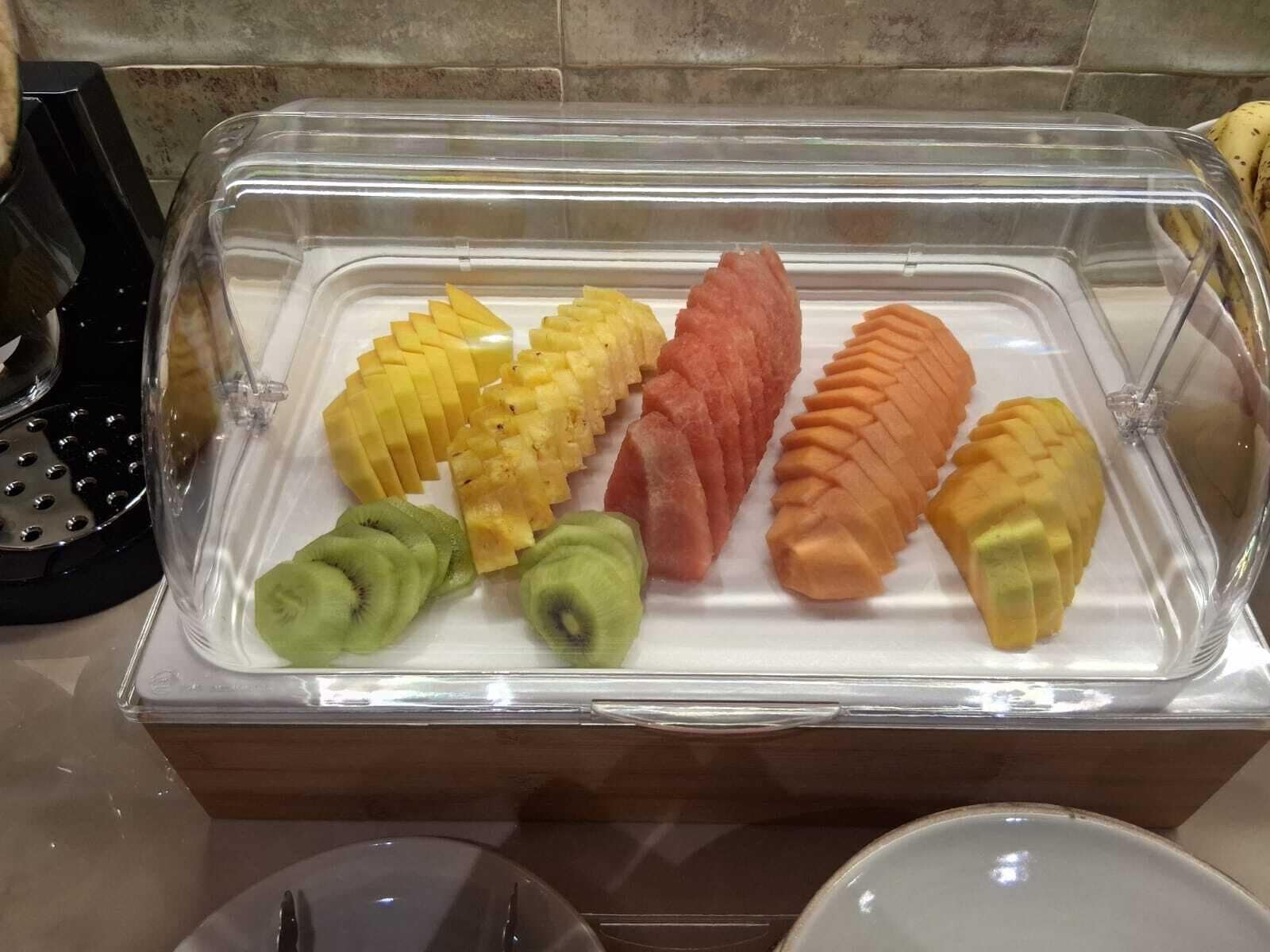 A buffet with various fruits including pineapple, mango, and kiwi.